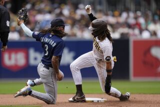 San Diego Padres' Fernando Tatis Jr., right, gets up after safely steals second base as Seattle Mariners shortstop J.P. Crawford looks on during the fourth inning of a baseball game Wednesday, June 7, 2023, in San Diego. Tatis Jr. advanced to third on the throwing error by catcher Cal Raleigh. (AP Photo/Gregory Bull)