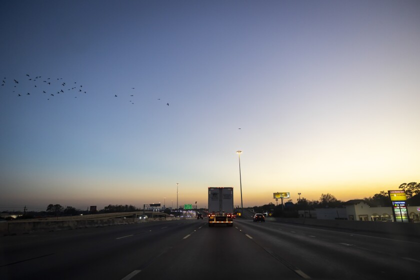 Margie Gilles, who cooks in the cab of her truck, drives southbound on Highway 69 just north of Houston, Dec. 12, 2021.