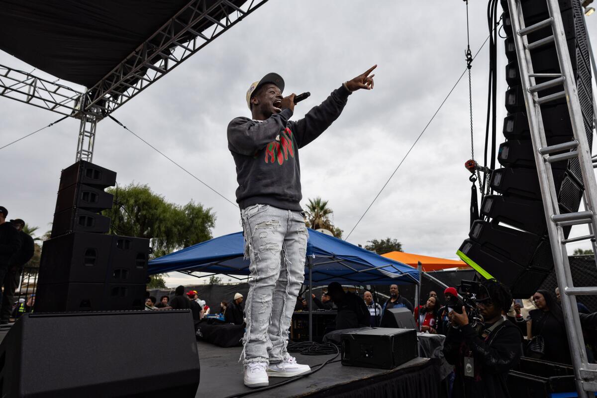 Ray Vaughn addresses the crowd at Top Dawg Entertainment's annual toy drive and concert at the Nickerson Gardens housing project Tuesday in Los Angeles.