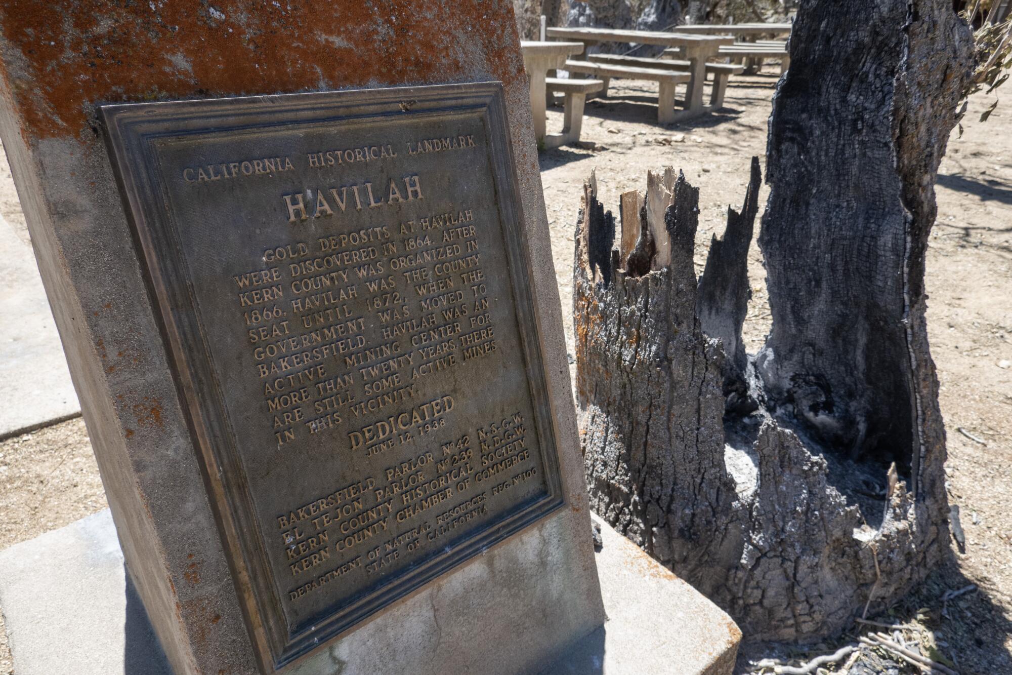 A historic sign stands among the charred rubble of Havilah.  