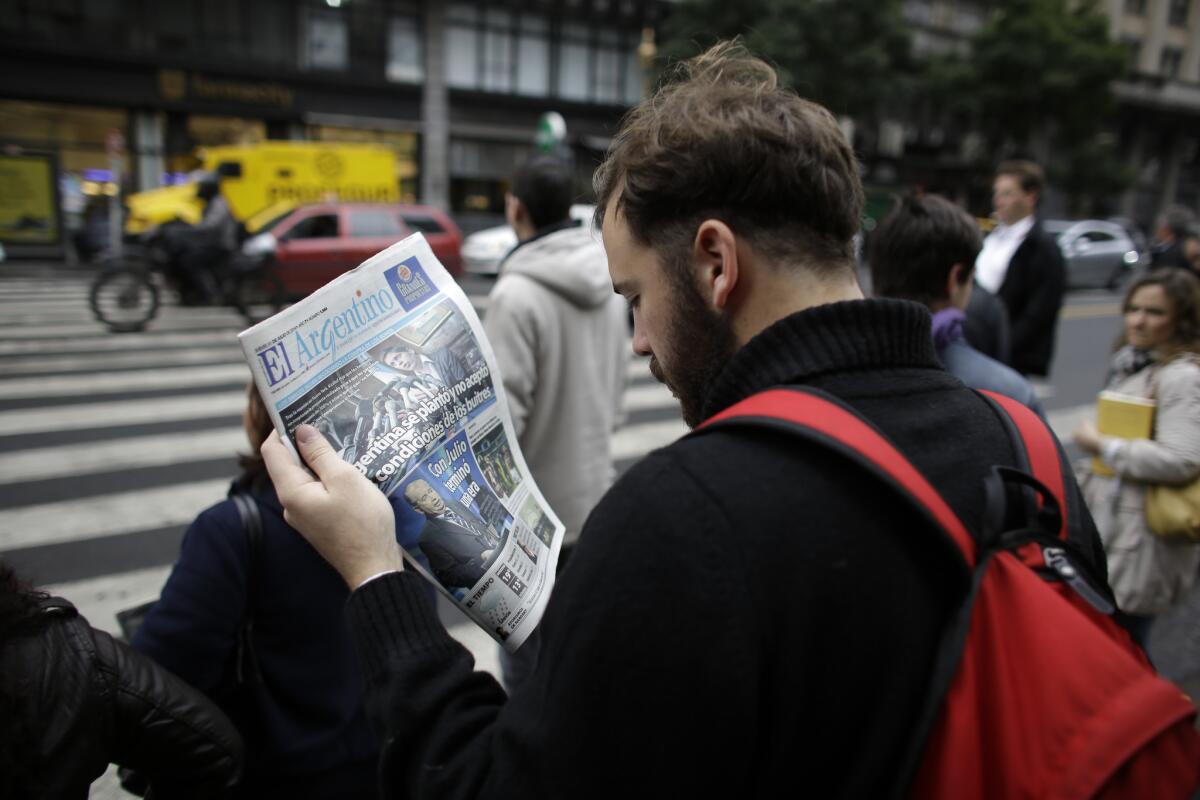 A man reads a newspaper in Buenos Aires on Thursday with a headline that reads in Spanish: "Argentina didn't accept the conditions of the vultures," referring to the dispute over Argentina's international debt.