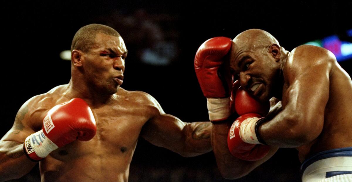 Mike Tyson, left, lands a blow to the chin of Evander Holyfield during their bout June 28, 1997, in Las Vegas.