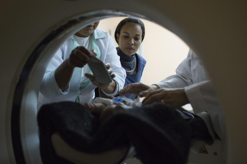 In Campina Grande, Brazil, Amanda dos Santos, 19, watches as medical technicians prepare her baby, 3-month-old Emanuel, before he undergoes a CT scan of his brain.