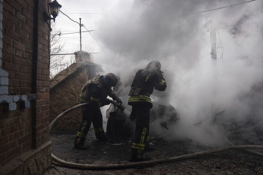 Bomberos extinguen un auto incendiado que fue bombardeado por fuerzas rusas en el barrio residencial en Kostiantynivka, Ucrania, el viernes 10 de marzo de 2023. (AP Foto/Evgeniy Maloletka)