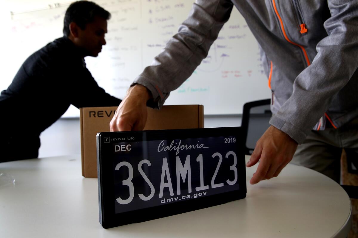 A digital California license plate is displayed on a table