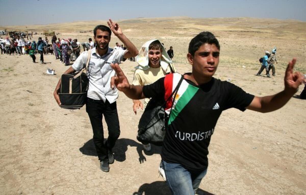 Syrian refugees cross the border into the autonomous Kurdish region of northern Iraq on Sunday.