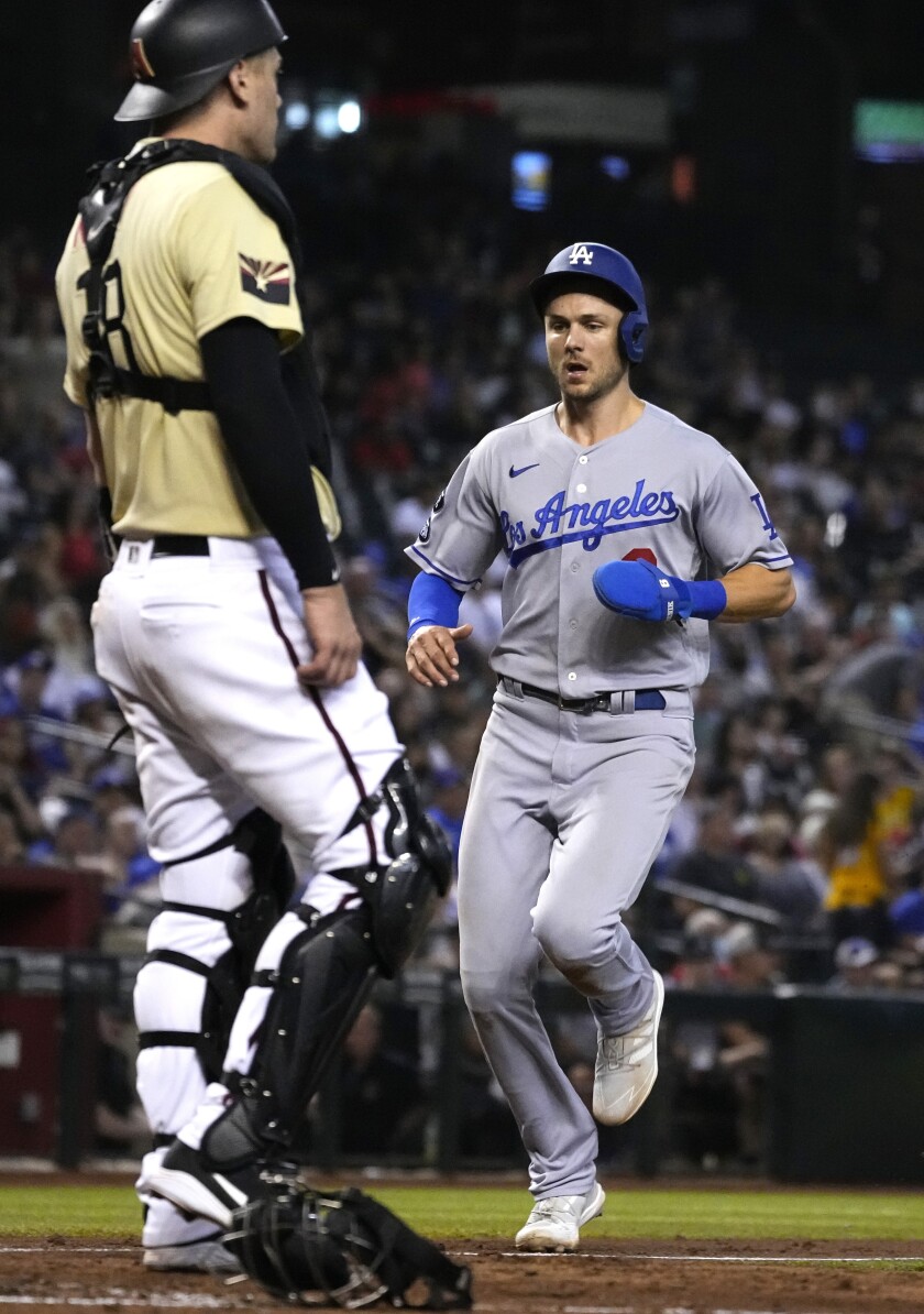 Trea Turner scores in front of Diamondbacks catcher Carson Kelly on a sacrifice fly by Will Smith in the sixth inning.