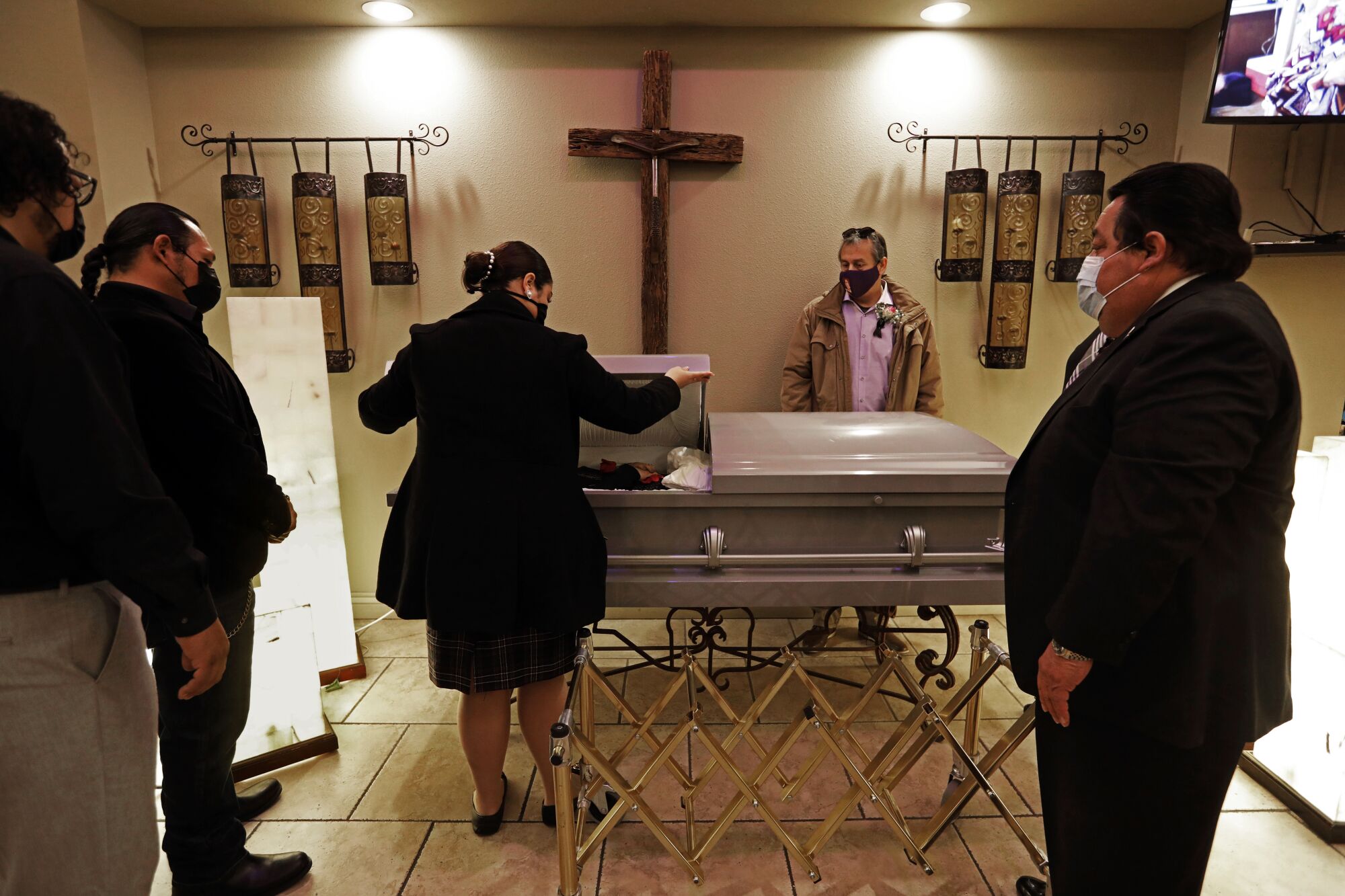 Funeral director Richard Villa, far right, oversees the closing of a casket of Aurora Duran, 65, who died of COVID-19.