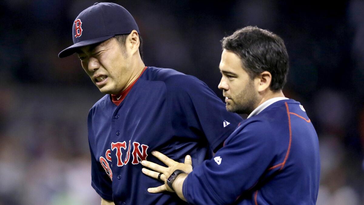 Red Sox relief pitcher Koji Uehara is helped off the field after a groundball hit by Detroit's Ian Kinsler struck him in the the right wrist on Friday.