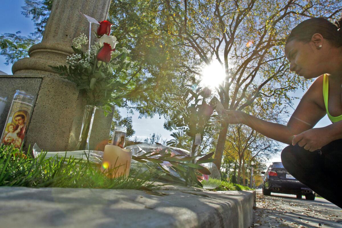 A Playa Vista resident pays her respect in 2011 at a memorial created for Reginald Doucet Jr., who was killed by an LAPD officer during a confrontation.