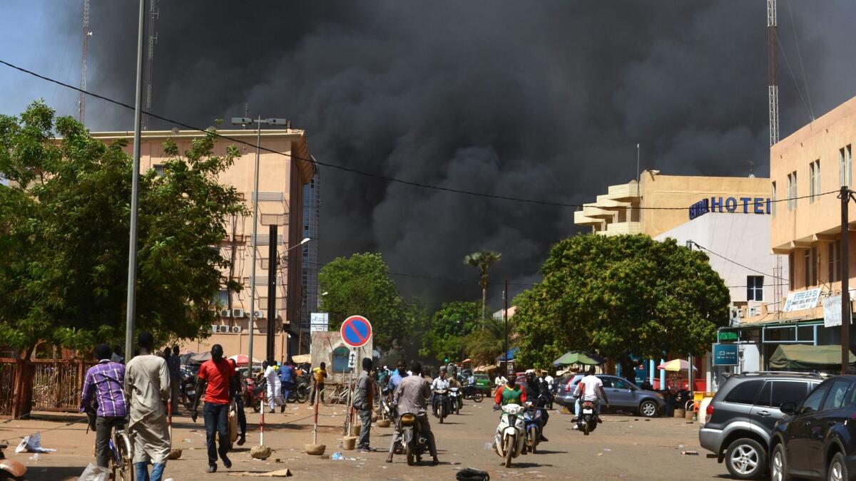 People watch black smoke rising during attacks on Burkina Faso's capital, Ouagadougou, on March 2.