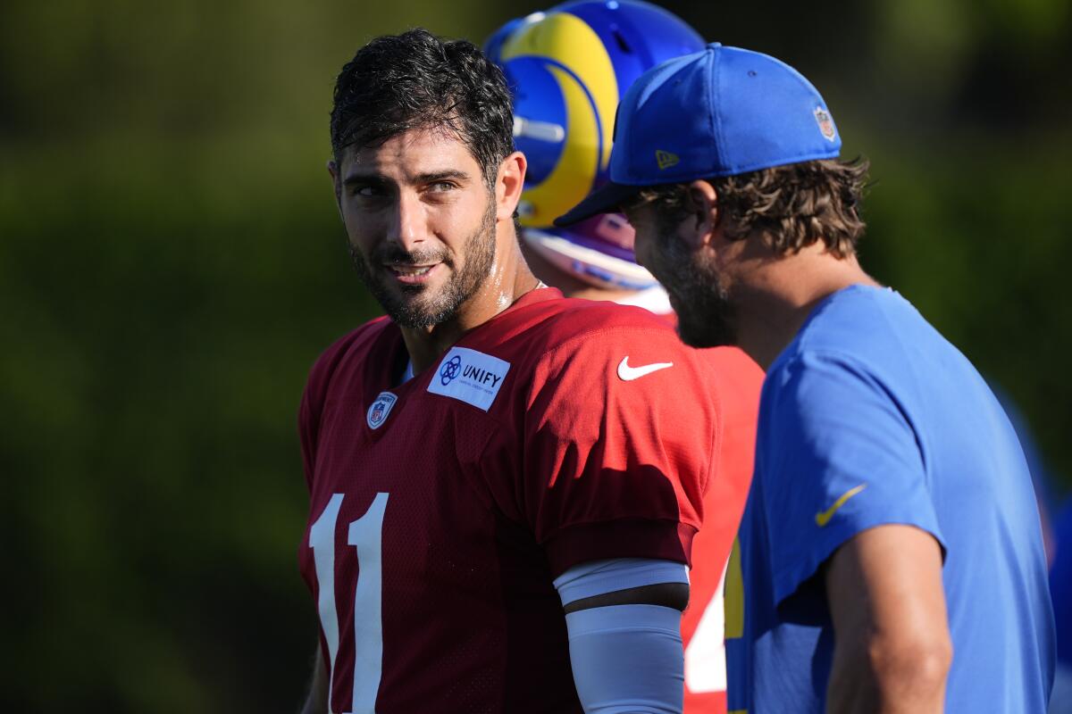Rams quarterback Jimmy Garoppolo, left, speaks with Matthew Stafford, who was not dressed for practice Monday.