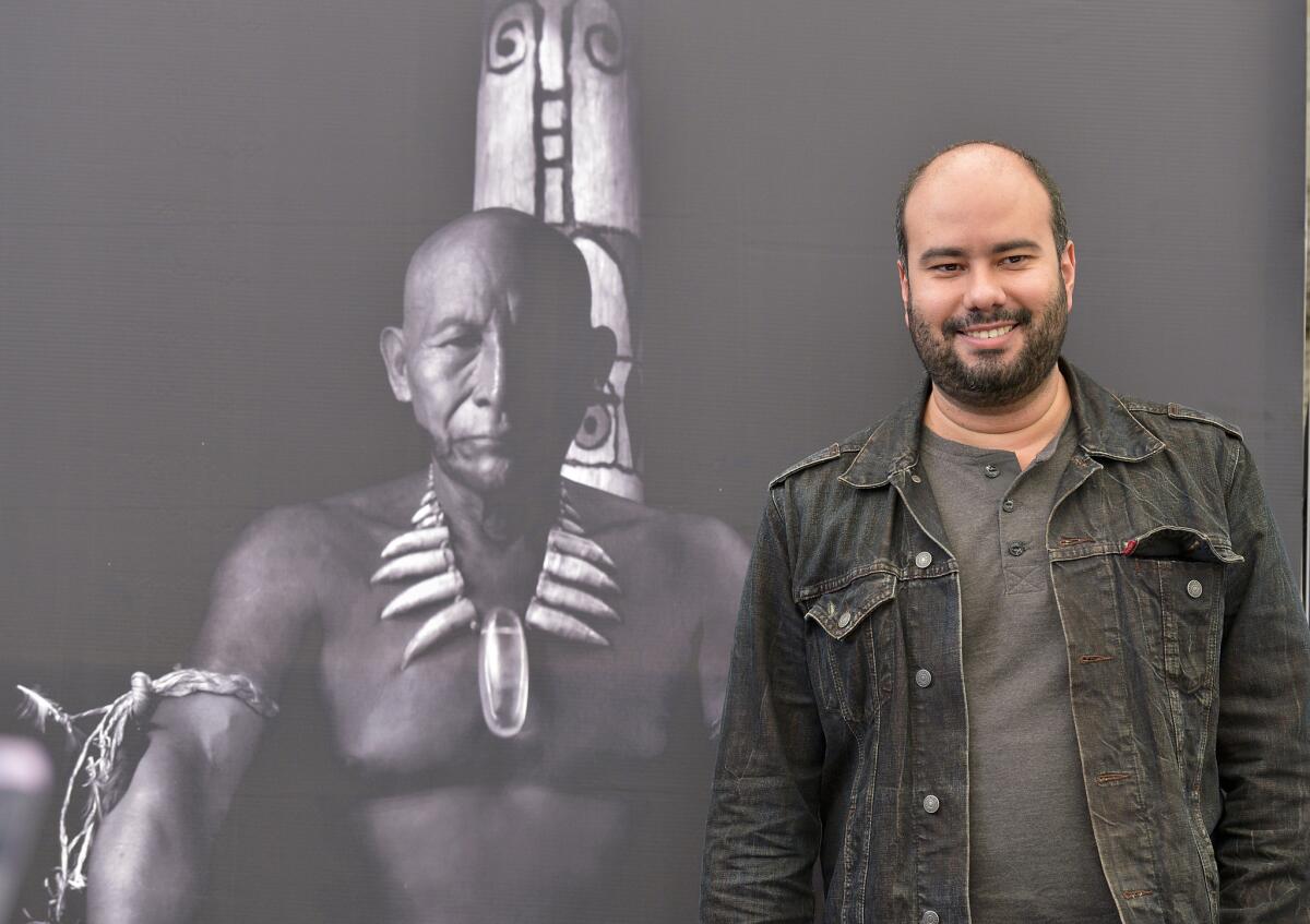 Colombian director Ciro Guerra, a first-time Oscar nominee, stands in front of a poster for his film "Embrace of the Serpent," in Bogota, Colombia.