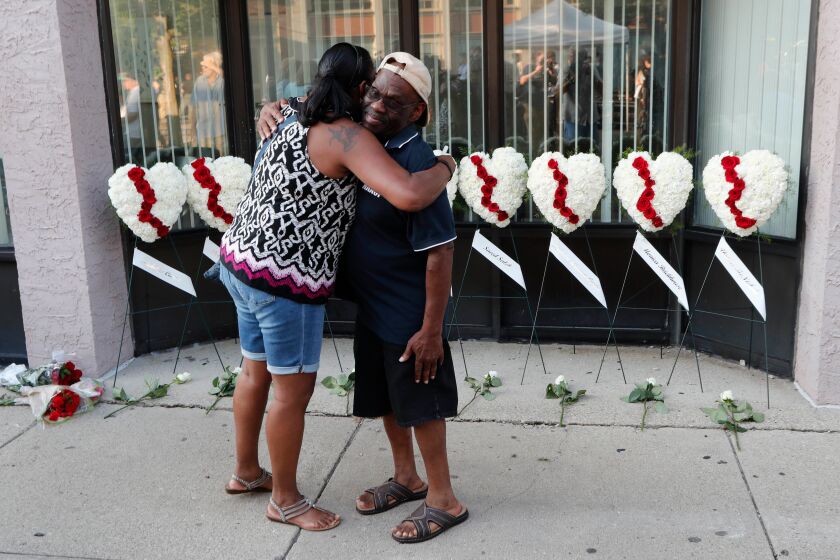Mandatory Credit: Photo by DAVID KOHL/EPA-EFE/REX (10354215h) Celeste Pickett (L) and Willie Terrel (R) hug each other in front of wreaths displayed for the nine victims of a shooting in the Oregon District of Dayton, Ohio, USA, 04 August 2019. According to officials, nine people were killed and 16 others were wounded and are being treated in local hospitals. The shooter, identified by officials as 24-year-old Connor Betts, was killed by police. Dayton mass shooting aftermath, USA - 04 Aug 2019 ** Usable by LA, CT and MoD ONLY **