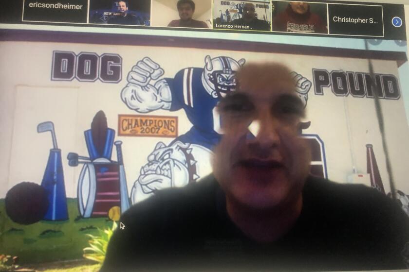 Garfield football coach Lorenzo Hernandez, using his virtual background, talks to his coaches while a sportswriter watches on during a Zoom video conference.