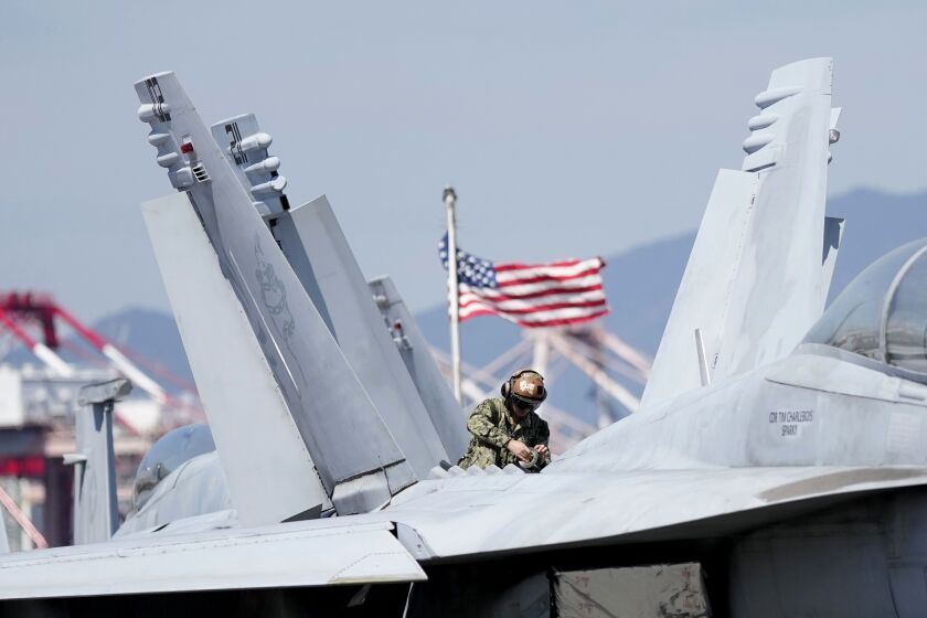 U.S. soldier checks the F/A-18 Super Hornet fighter jet on the deck of the nuclear-powered aircraft carrier USS Ronald Reagan in Busan, South Korea, Friday, Sept. 23, 2022. The nuclear-powered aircraft carrier USS Ronald Reagan arrived in the South Korean port of Busan on Friday ahead of the two countries' joint military exercise that aims to show their strength against growing North Korean threats. (AP Photo/Lee Jin-man)