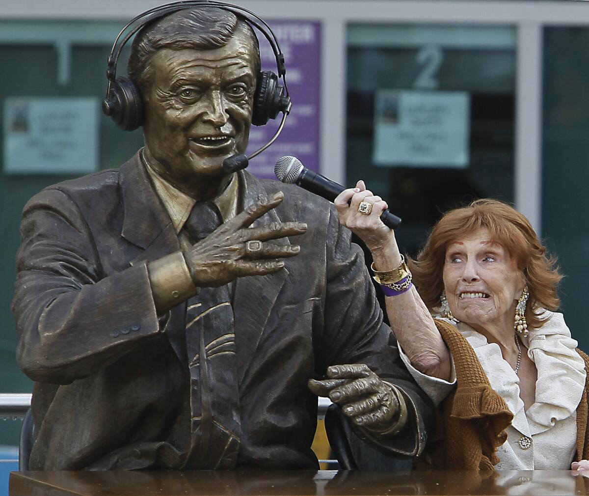 Marge Hearn playfully poses with a statue of her late husband Chick Hearn outside Staples Center in 2010.