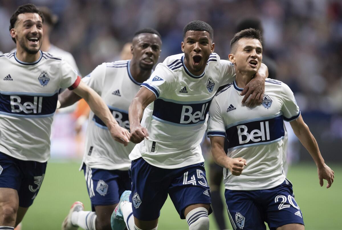 The Vancouver Whitecaps' Andrés Cubas (20) rejoices with his teammates after scoring July 2, 2022.