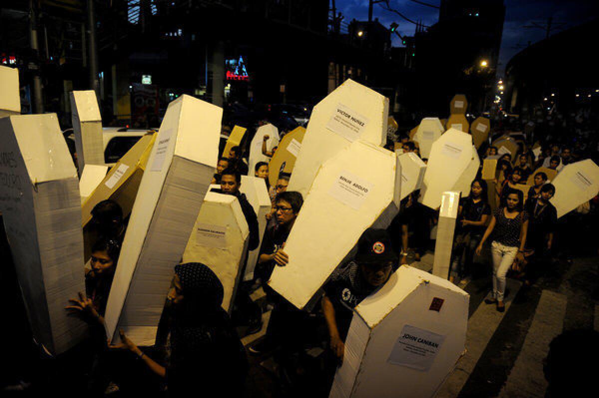 Philippine journalists and students carry mock coffins as they march toward Malacanang Palace in Manila to commemorate the third anniversary of the Nov. 23 Maguindanao massacre.