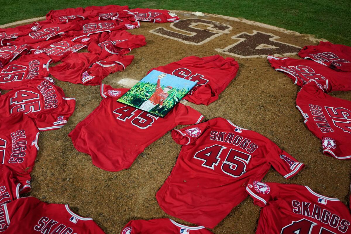A portrait of the late Angels pitcher Tyler Skaggs sits atop the jerseys on the pitcher's mound at Angel Stadium
