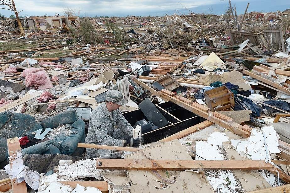 Air Force Airman 1st Class Justin Acord sifts through the rubble of his father-in-law's home in Moore, Okla., after the town was hit by a tornado the day before.
