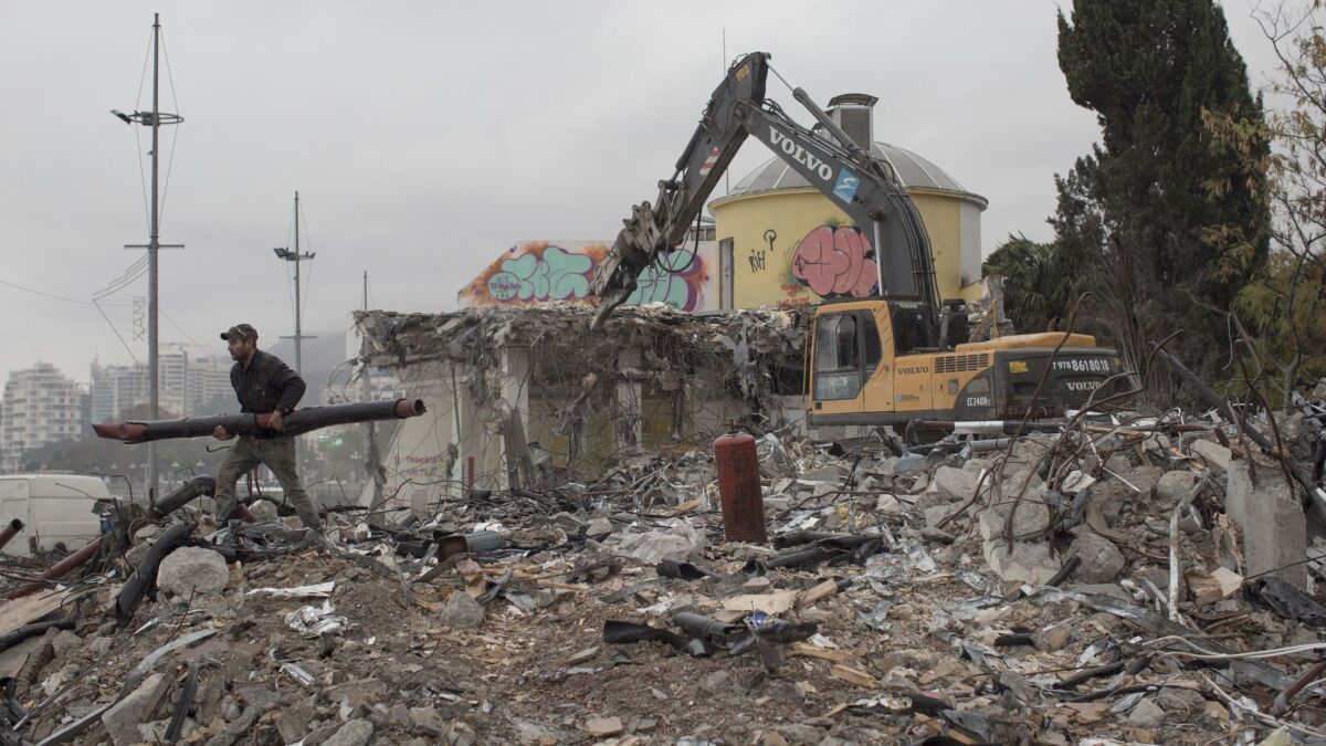 Workers demolish Eda, a seaside shopping mall in the Crimean city of Yalta that reportedly belongs to Ukrainian oligarch Rinat Akhmetov. (Denis Sinyakov / For The Times)