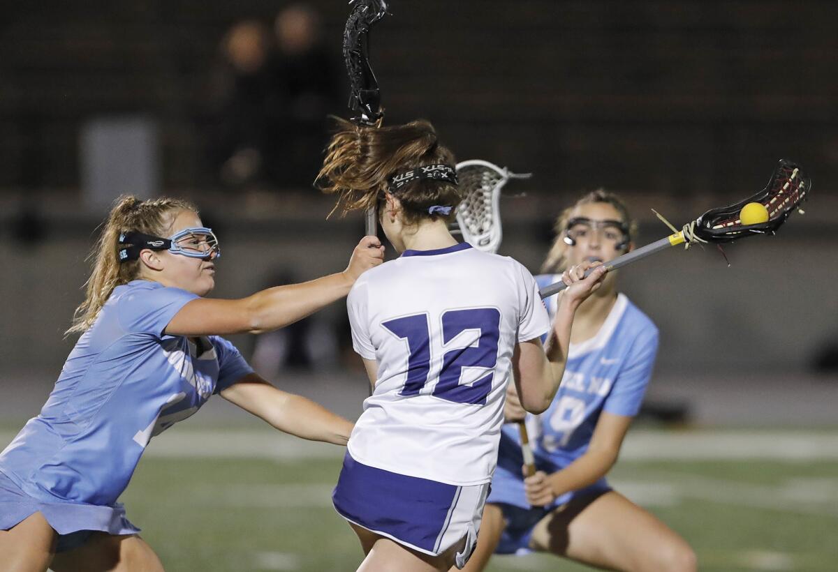Newport Harbor's Olivia Gritzmacher (12) is met by Kate Kittleson's stick during Thursday's match.