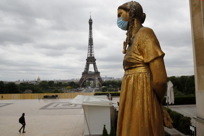 FILE- In this file photo dated Monday, May 4, 2020, a statue wears a mask along Trocadero square close to the Eiffel Tower in Paris. In a study published Tuesday May 5, 2020, in the International Journal of Microbial Agents, doctors at a hospital north of Paris reviewed retrospective samples of 14 patients treated for atypical pneumonia, and say they may have identified a possible case of the new coronavirus dating back to December 2019. (AP Photo/Christophe Ena, FILE)