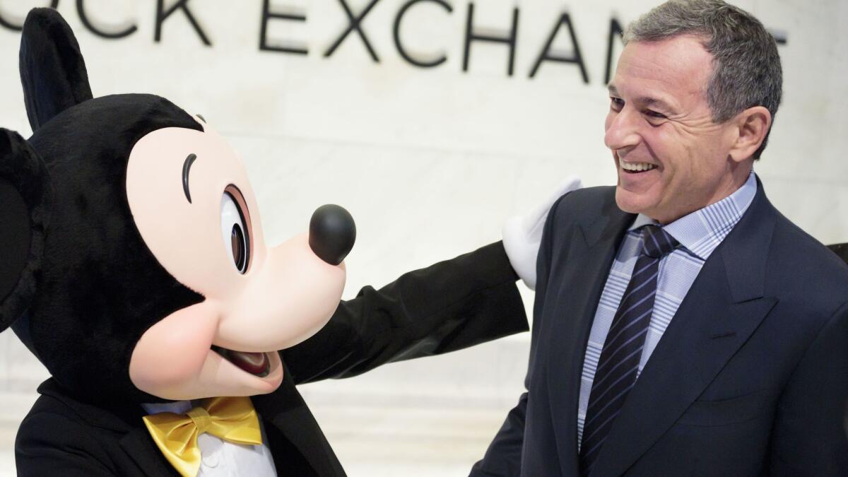 Mickey Mouse and Robert Iger, chief executive of Walt Disney Co., stand together before ringing the opening bell of the New York Stock Exchange on Nov. 27.