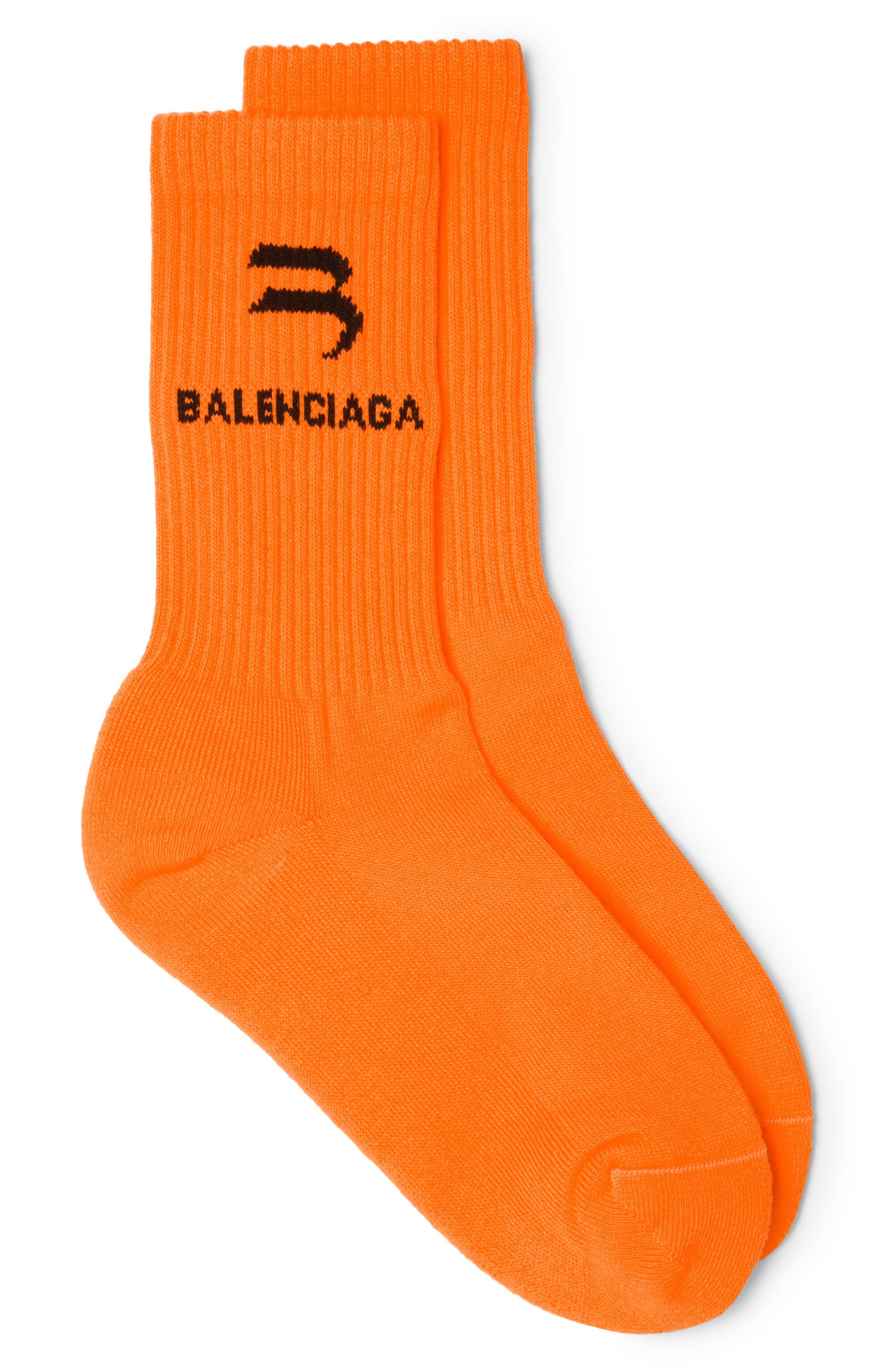 Orange crew socks with a black Balenciaga logo