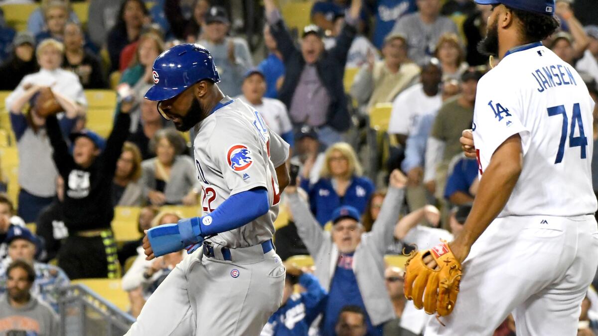 Jason Heyward crosses home plate ahead of Dodgers closer Kenley Jansen after a passed ball allowed the Cubs outfielder to score the tying run in the ninth inning.