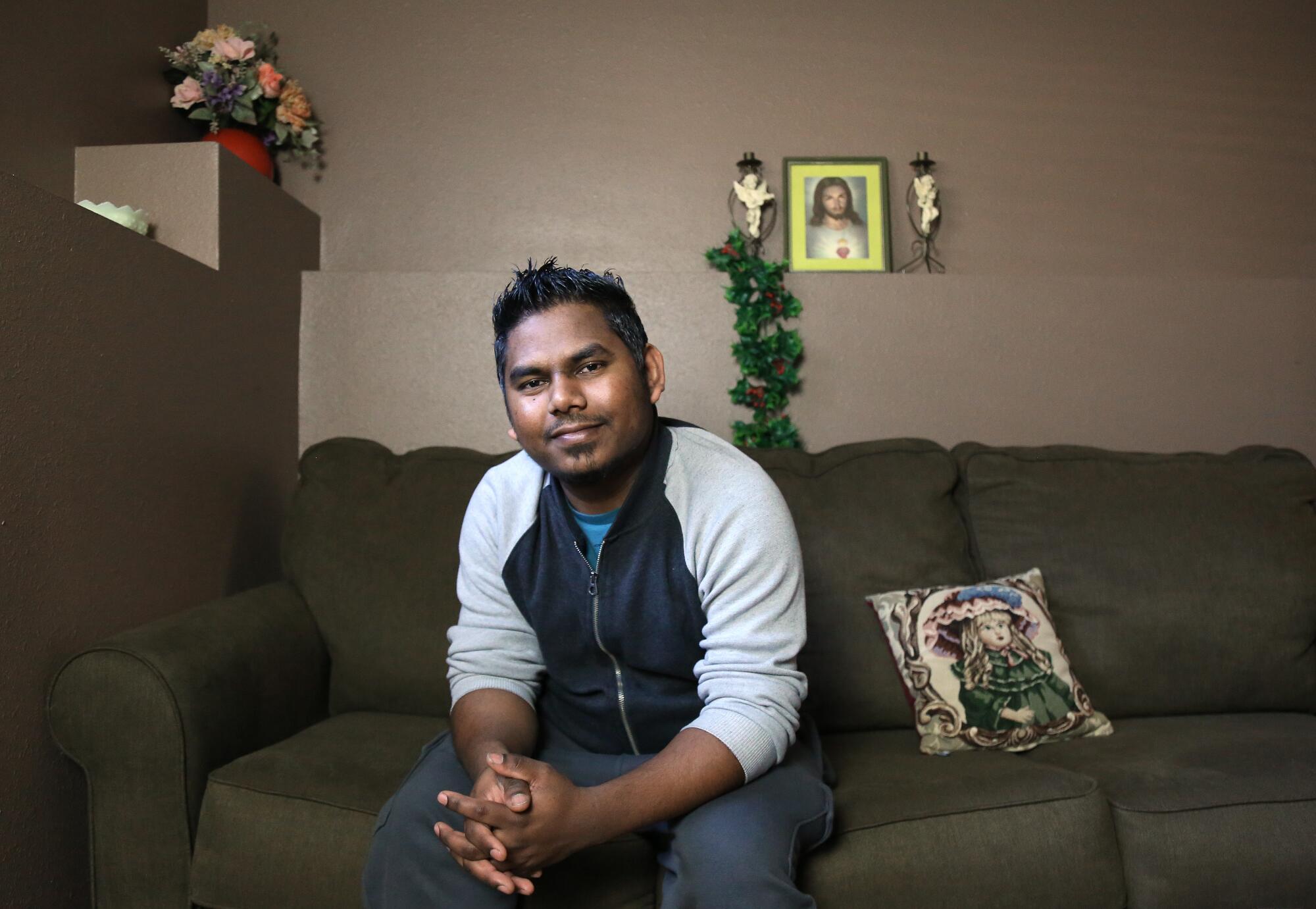 Urwan pictured on a couch that he had converted into a bed when he slept in his basement with COVID-19.