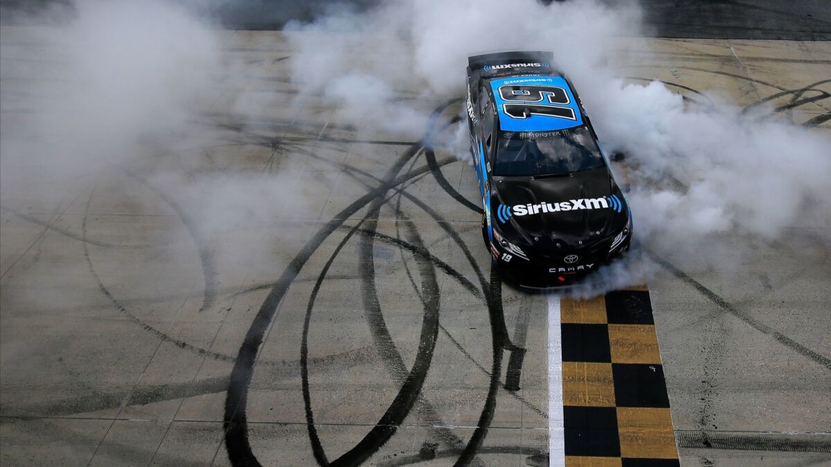Martin Truex Jr. celebrates with a burnout after winning a NASCAR race at Dover International Speedway on May 6.