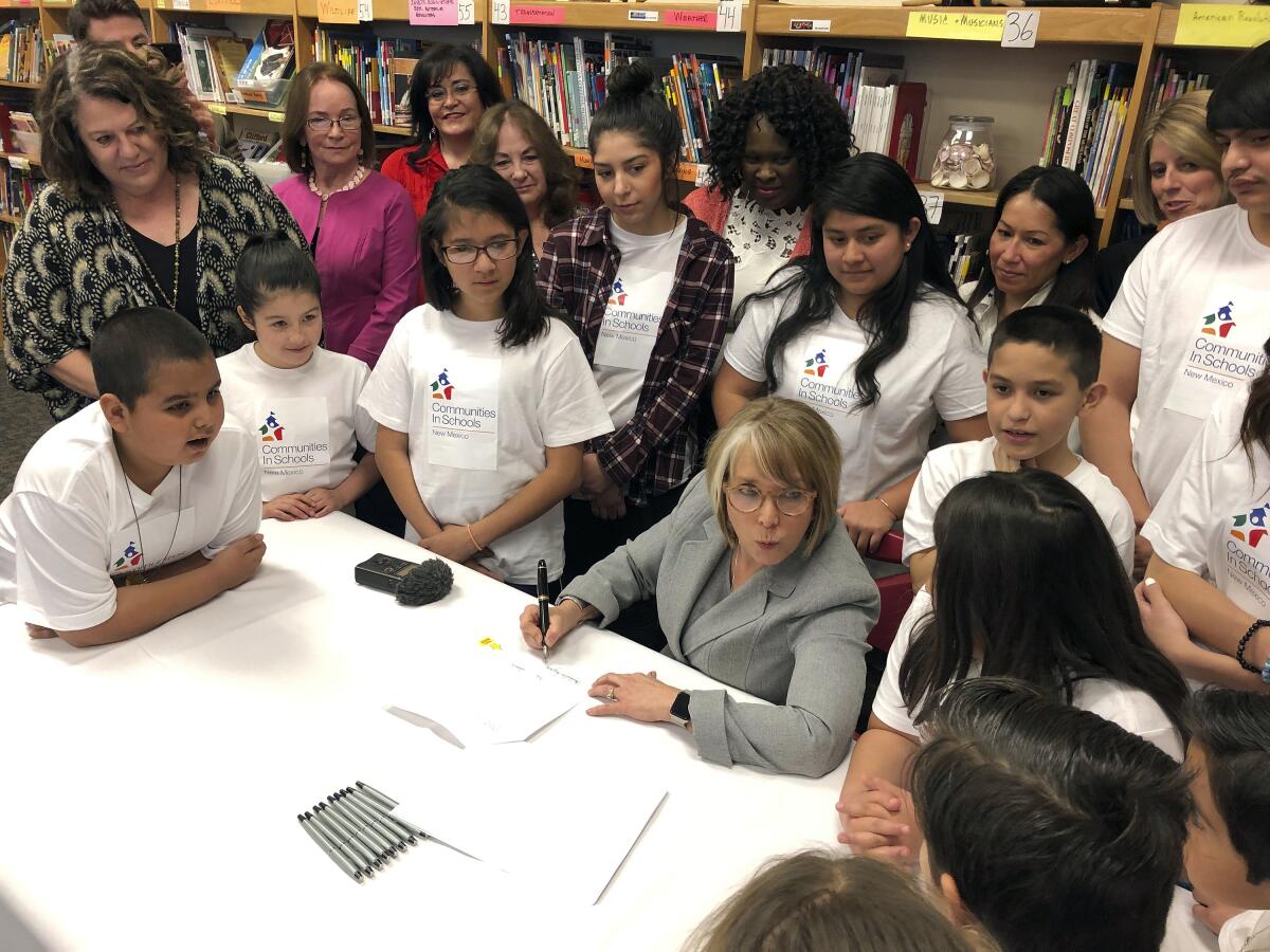 FILE - In this April 3, 2019 file photo, New Mexico Gov. Michelle Lujan Grisham signs legislation to raise teacher salaries and increase annual spending on public schools by almost a half-billion dollars at Salazar Elementary School in Santa Fe, N.M. New Mexico has retained its title as the nation's most heavily Latino state, with 47.7% of respondents to the 2020 census identifying ancestry linked to Latin America and other Spanish-speaking areas. The Census Bureau on Thursday, Aug. 12, 2021 released new demographic details culled from the census. (AP Photo/Morgan Lee, File)