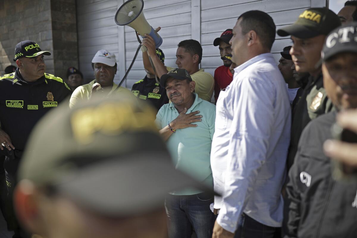 Luis Manuel Díaz conversa con sus vecinos en su casa en Barrancas, Colombia