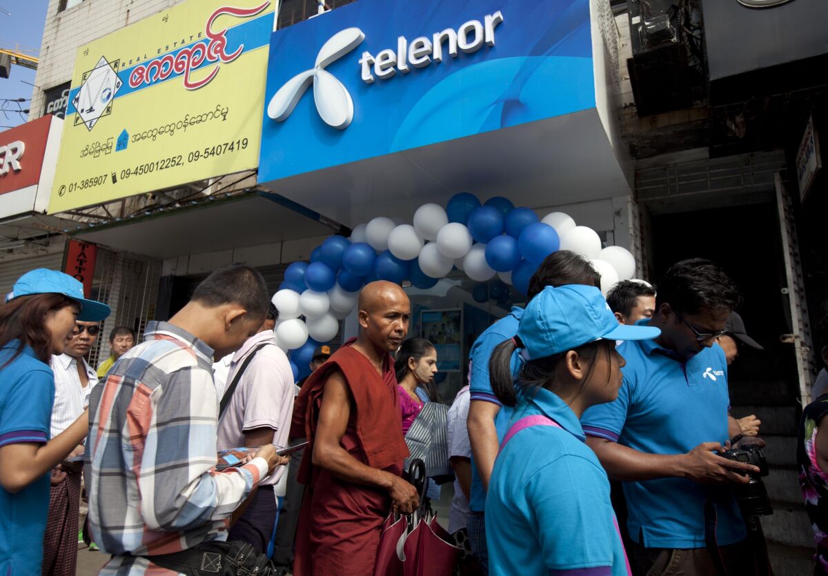 FILE - In this Oct. 26, 2014, file photo, customers line up outside a showroom to buy SIM cards at Telenor, Norwegian telecommunication company, in Yangon, Myanmar. A customer of Telenor's Myanmar telecommunications business has filed a complaint Monday, Feb. 7, 2022, with Norway’s data protection authority saying the company's plan to sell the business risks a potentially dangerous breach of privacy, the law firm representing the person said. (AP Photo/Khin Maung Win, File)