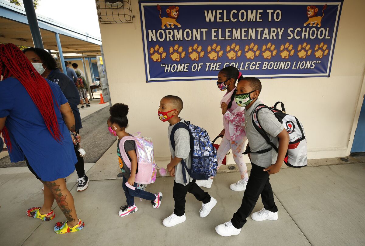 Students walk into their elementary school. 