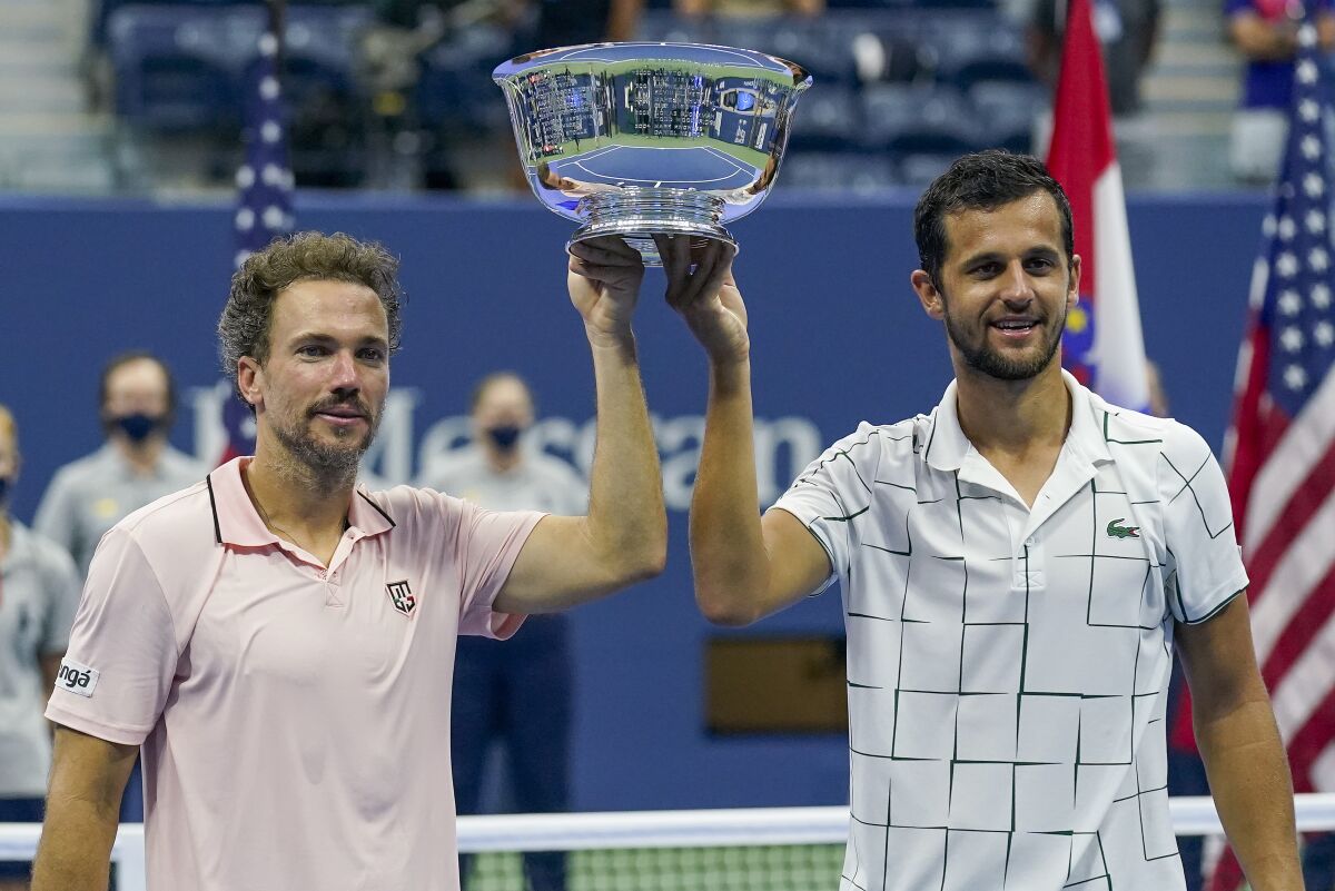 Bruno Soares, of Brazil, left, and Mate Pavic, of Croatia, hold up the championship trophy after winning the men's doubles final against Wesley Koolhof, of the Netherlands, and Nikola Mektic, of Croatia, during the US Open tennis championships, Thursday, Sept. 10, 2020, in New York. (AP Photo/Seth Wenig)