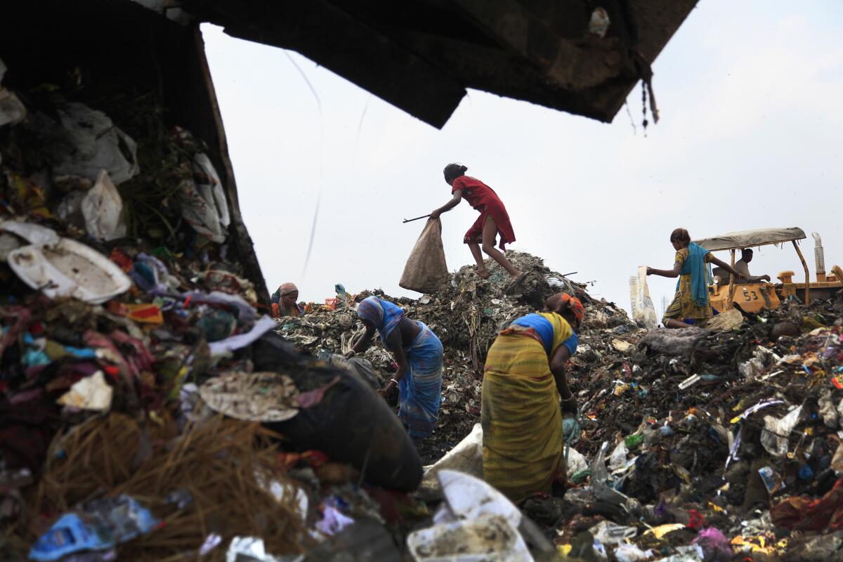 Trash pickers scavenge inside Delhi's 70–acre, 100–foot high Ghazipur landfill.