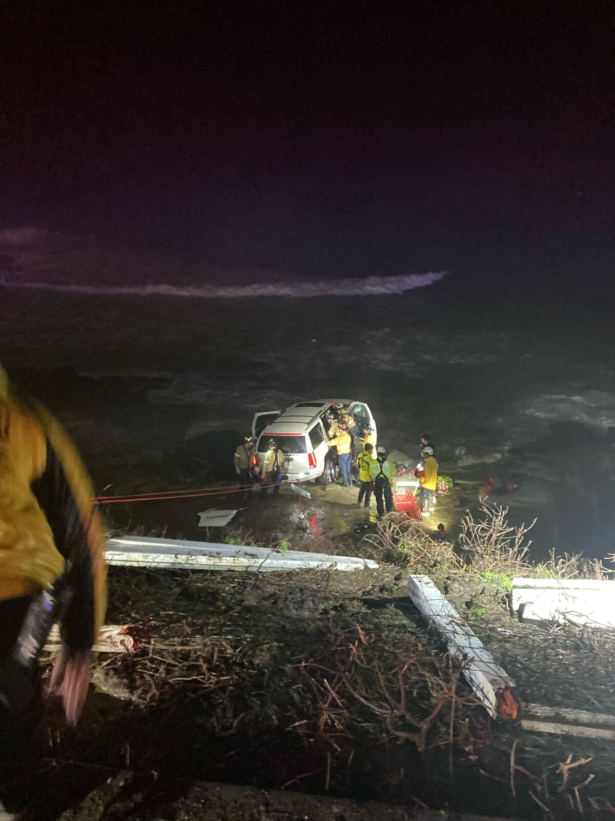 Firefighters work to rescue a driver whose vehicle went off Coast Boulevard and down a cliff in La Jolla on Jan. 14.