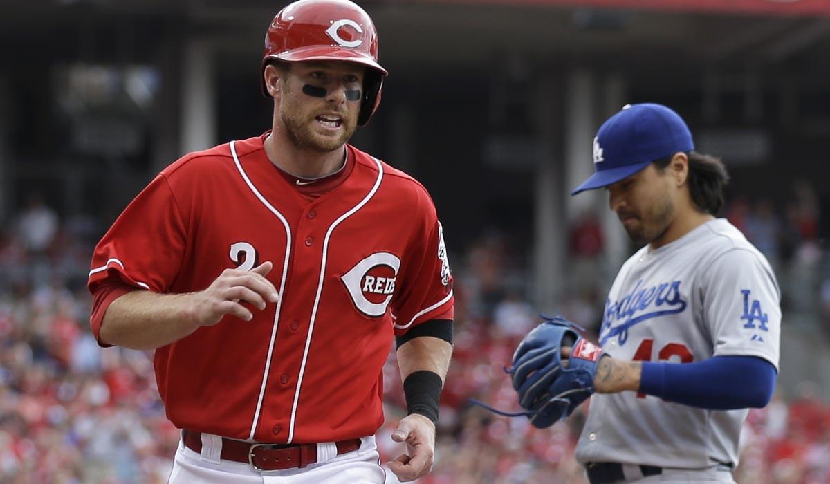 Reds shortstop Zack Cozart scores on a wild pitch by Dodgers relief pitcher Brandon League, right, in the eighth inning Thursday.