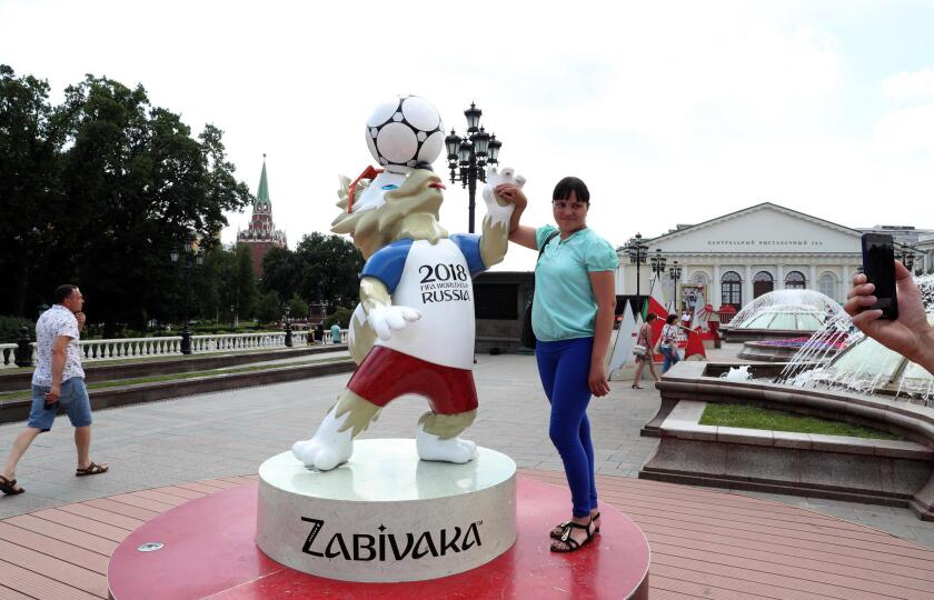 A woman poses with a statue of Zabivaka, the official mascot of the 2018 FIFA World Cup in central Moscow, Russia, 29 June 2018. The FIFA World Cup 2018 takes place in Russia from 14 June until 15 July 2018.