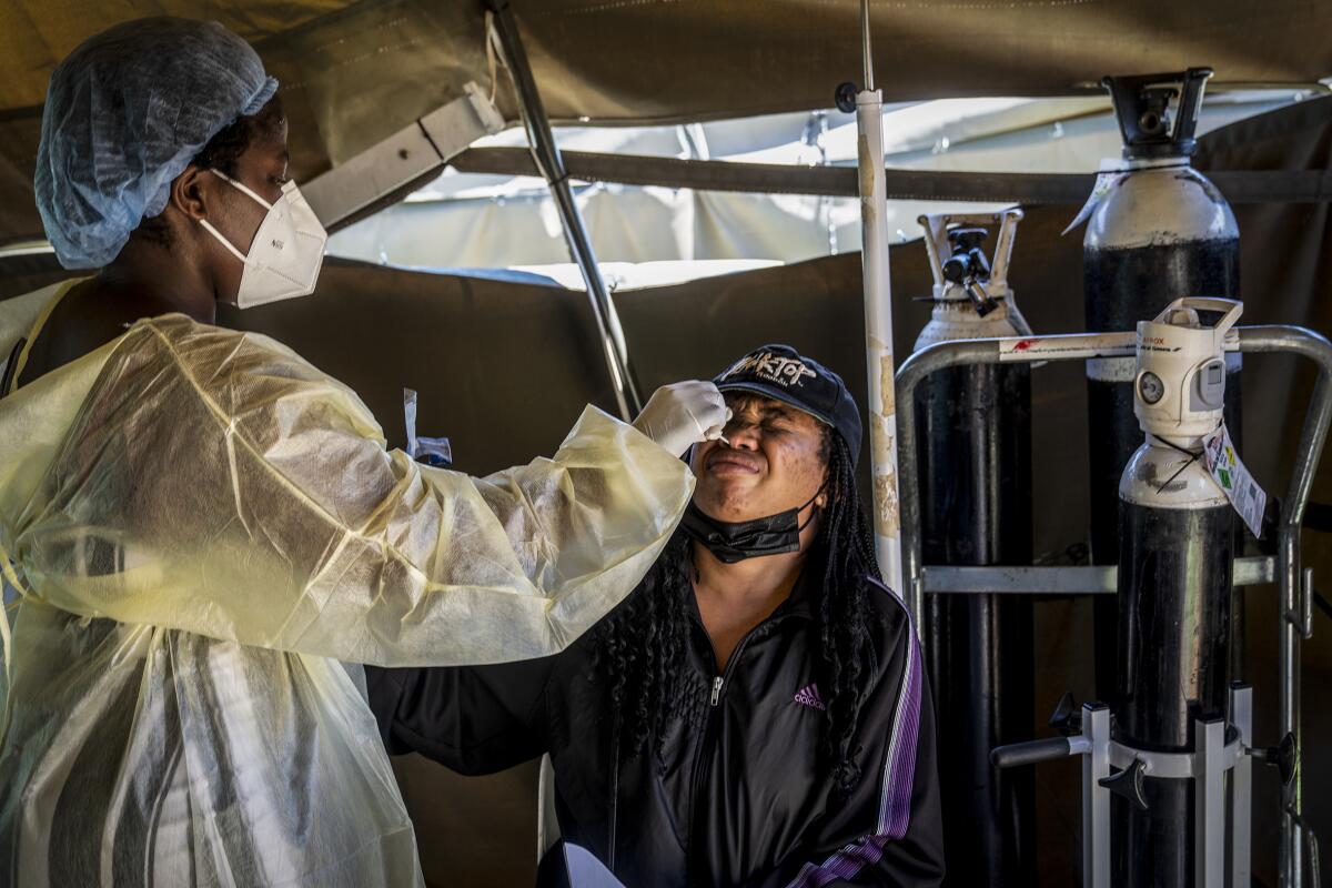 A person in personal protective equipment administers a coronavirus test.