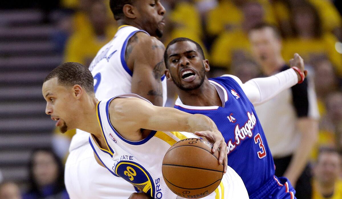 Clippers point guard Chris Paul tries to follow Warriors point guard Stephen Curry around a screen by Andre Iguodala during Thursday night's game in Oakland.