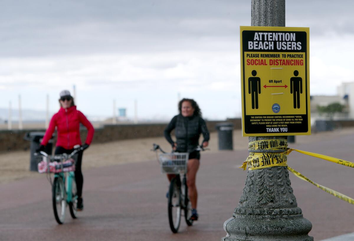 Bicycle riders practice social distancing just north of the Huntington Beach Pier on April 10.