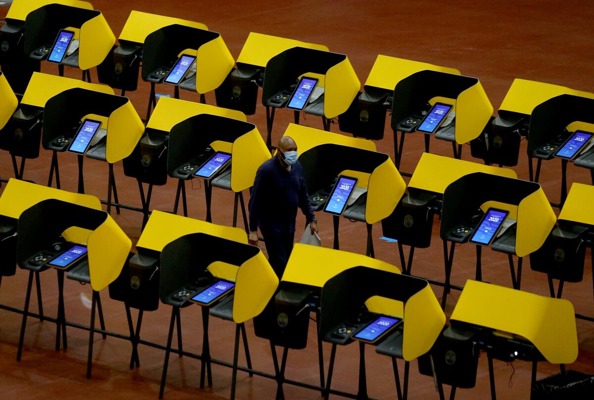 A person walks among voting booths after casting a ballot.