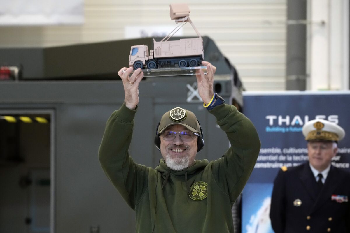 Ukrainian Minister of Defense Oleksii Reznikov, holds a Ground Master 200 radar small model during a visit at Thales radar factory in Limours, south west of Paris, France, Wednesday, Feb. 1, 2023. France has guaranteed Kyiv the delivery of a Ground Master 200 (GM200) radar, produced by the French manufacturer Thales. This medium-range radar is capable of spotting enemy aircraft at 250 km and engaging them at 100 km, whether they are flying at low speed and low altitude like drones or at high altitude like fighter planes. (AP Photo/Christophe Ena)