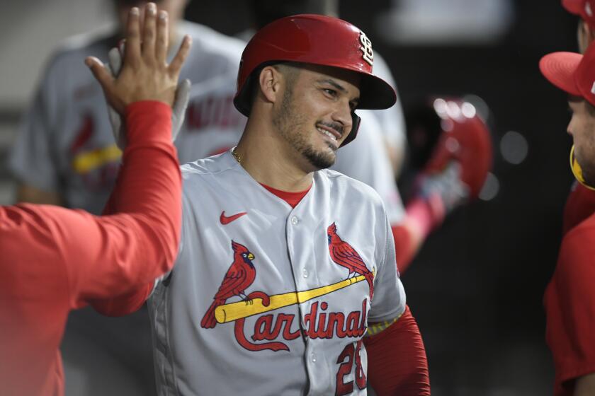 St. Louis Cardinals' Nolan Arenado (28) celebrates with teammates in the dugout after hitting a two-run home run.