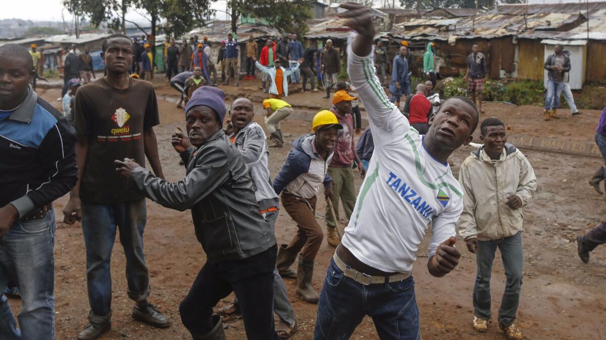 Opposition protesters In Kibera slum district in Nairobi throw stones at police during Thursday's controversial repeat election.