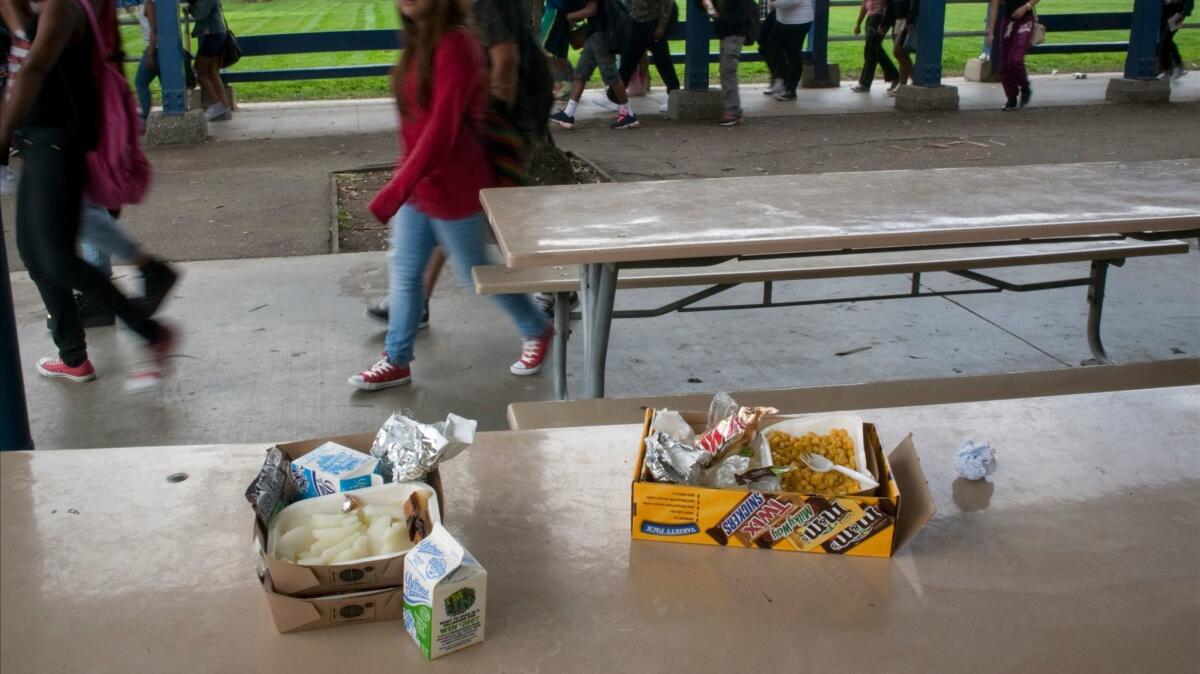 Half-eaten lunches remain on cafeteria tables in March 2014 at L.A.'s Washington Prep High School. Not all students like healthier meals or what they taste like after being delivered from a central kitchen, and then are re-heated.